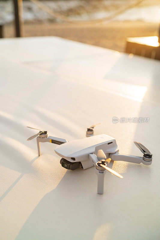西班牙玛贝拉——2022年6月9日:大疆Mavic Mini SE无人机准备在日出时在玛贝拉海滩飞行